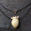 Close-up View Hand-Carved Mammoth Tusk Human Heart Necklace on Double Strand Leather Cord
