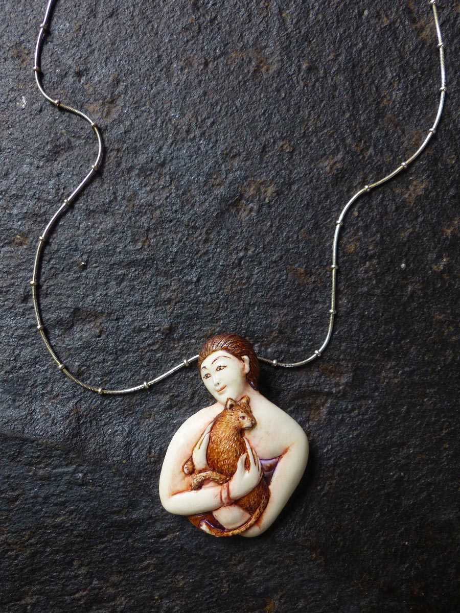 Close-Up-Hand-Carved-Hand-Painted-Bone-Woman-Holding-Cat-Necklace-by-Susan-Tereba